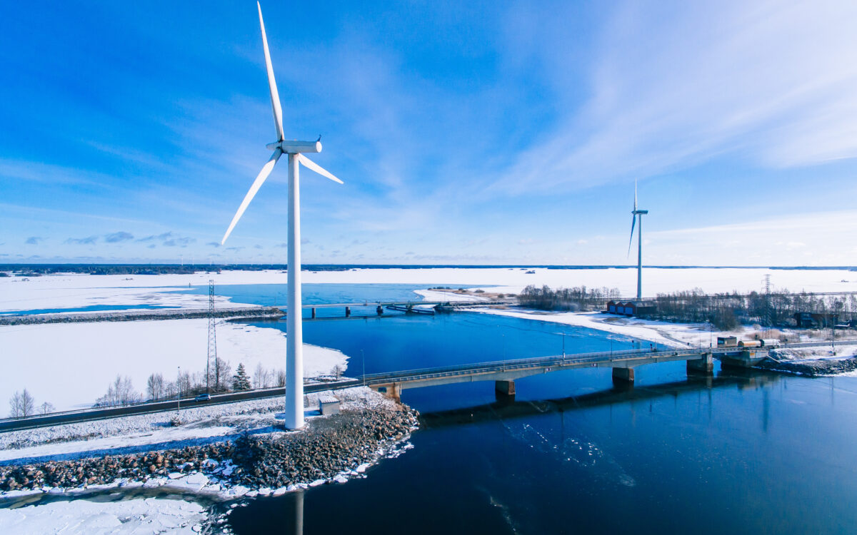 Aerial view of windmills with blue frozen river in snow winter Finland. Wind turbines for electric power with clean and Renewable Energy | turbinesinfo.com