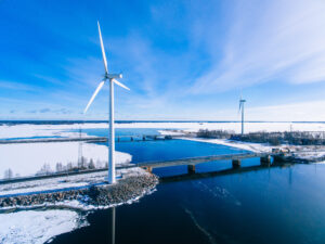 Aerial view of windmills with blue frozen river in snow winter Finland. Wind turbines for electric power with clean and Renewable Energy | turbinesinfo.com